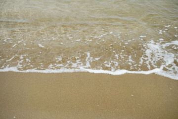 Fototapeta na wymiar closeup of sea foam on a sandy shore Mockup beach material