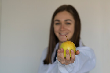 Female nutritionist shows an apple. Healthy eating concept