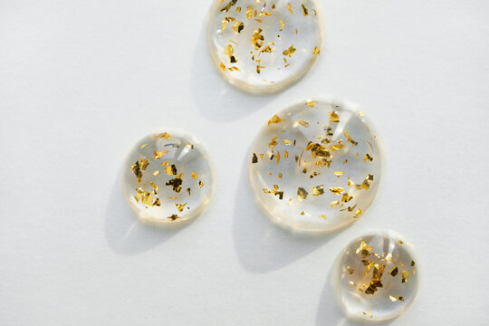Serum drops with gold particles close-up, copy space. Beauty skin care product swatch. - Powered by Adobe