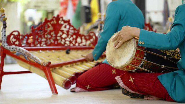 Asian men playing traditional bali music in temple. Close up of male musicians in national balinese clothing, dress use bamboo instrument xylophone Rindik and drum on ceremony 