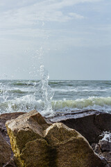 A shot of the sea surf. Splashes of water hitting the stone. Ocean surf among the rocks. Background...