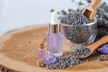 Aromatherapy. Massage and spa. Cosmetic bottles of lavender essential oil, dried flowers and lavender seeds on a wooden stand. Natural cosmetics for the body.