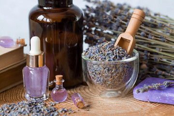 Aromatherapy. Massage and spa. Cosmetic bottles of lavender essential oil, old books, dried flowers...