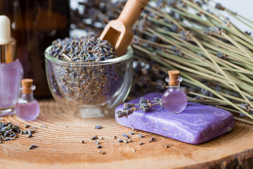 Aromatherapy. Massage and spa. Cosmetic bottles of lavender essential oil, dried flowers and lavender seeds on a wooden stand. Natural cosmetics for the body.