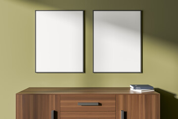 Cabinet with two posters on green wall