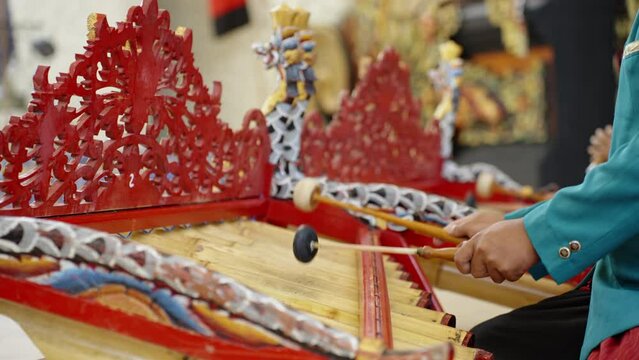 Close up of male musicians in national balinese clothing, dress use bamboo instrument xylophone Rindik on ceremony. Asian man's playing traditional bali music in temple
