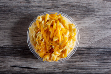 A top down view of a plastic container of macaroni and cheese.
