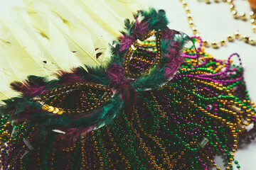 A view of a masquerade mask and Mardi gras beads.