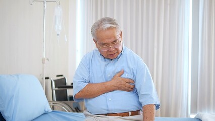 Elderly Asian man with chest pain suffering from heart attack. Man clutching his chest from acute pain. Heart attack symptom-Healthcare and medical concept