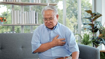 Elderly Asian man with chest pain suffering from heart attack. Man clutching his chest from acute...