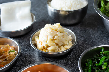 A view of several banchan side dishes, featuring macaroni salad.