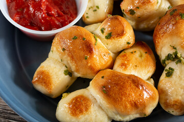 A closeup top down view of a bowl of garlic knots.