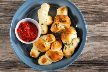 A top down view of a bowl of garlic knots.