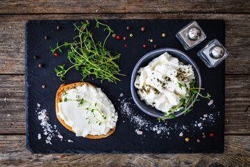 Cottage cheese sandwich with thyme on wooden table
