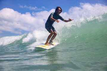 Portrait of carefree smiling man surfing in sea