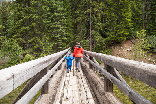 Mother and son hike across a wooden bridge in Manning Provincial Park.