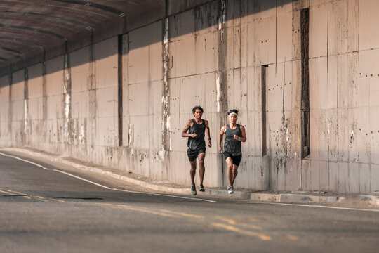 Male runners training on urban street in Brooklyn