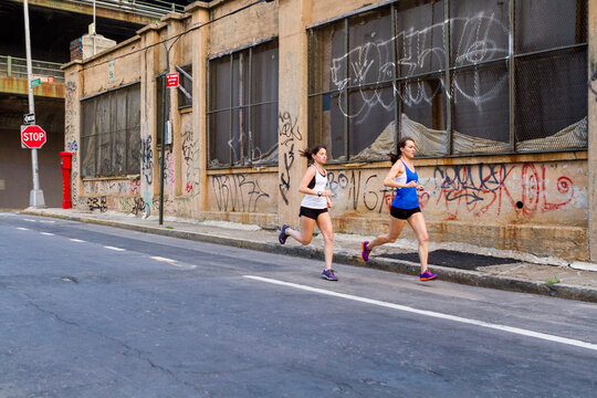 Female runners training in industrial area of Brooklyn