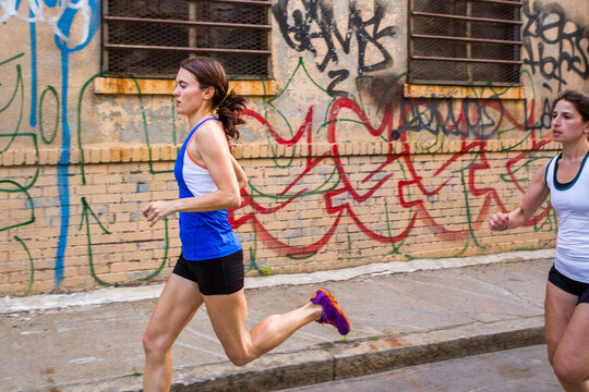 Female runners training in industrial area of Brooklyn