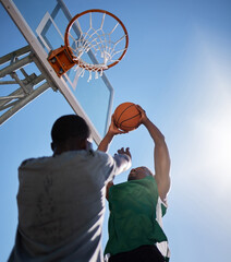 Basketball player, low angle and competition games on blue sky background of outdoor sports,...