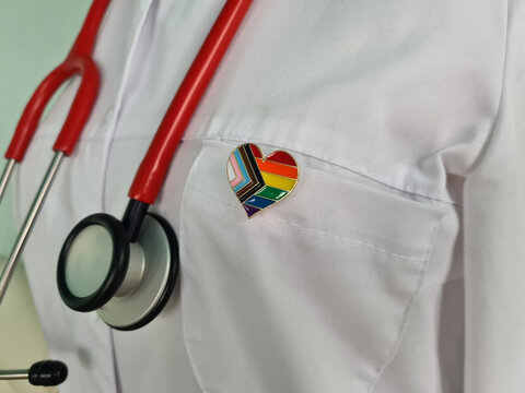 Silhouette of doctor in white coat with stethoscope and LGBT badge on pocket