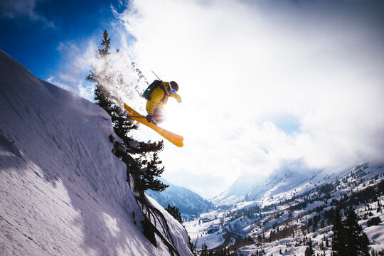 A man jumps off a cornice at sunset, Alta, Utah
