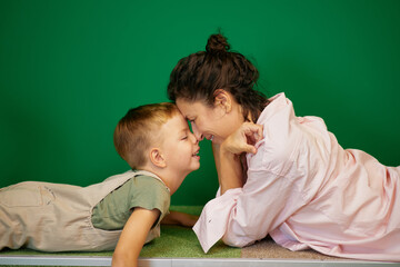 Happy smiling mom and small child enjoy morning together tender touching noses. Loving parent female enjoy spending time with boy at home on weekend. High quality photo