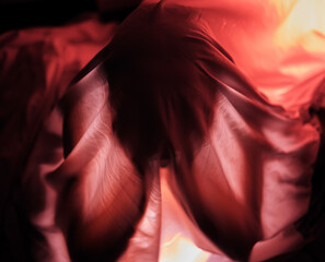 Obraz premium Red lighting, dark and person with fabric for depression, sadness and mental health problems. Creative art, psychology and sheet over head for loneliness, isolation and adult suffering with anxiety