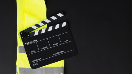 Clapper board or movie slate and Safety Vest on black background..