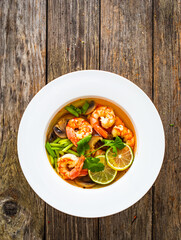 Thai seafood soup on wooden table
