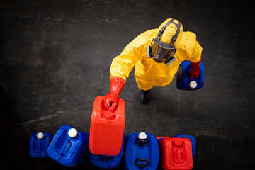 Obraz premium Professional worker in hazmat protection suit and gas mask working with dangerous chemicals inside factory.