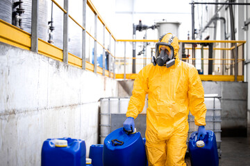 Worker wearing protection equipment and gas mask working in chemicals production factory.