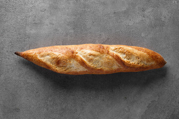 Rustic sourdough rye baguette with cereal on a gray table, top view