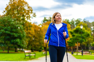 Nordic walking - woman training in city park
