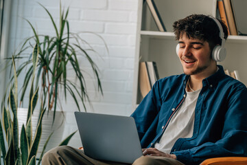 young man at home with laptop and headphones © carballo