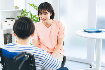 Fototapeta premium 車椅子に乗った男の子を診察する女性医療従事者