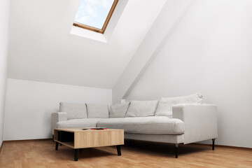 Attic room interior with slanted ceiling and furniture