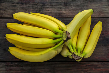 Ripe yellow bananas on wooden table, flat lay