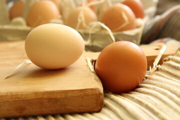 Homemade chicken eggs lie in straw on a wooden cutting board. Eggs in a tray. Cooking and recipes, eco, healthy eating, farming