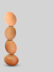 Stacked fresh chicken eggs against light grey background. Space for text