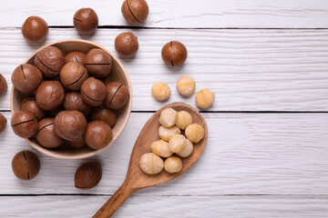 Delicious organic Macadamia nuts on white wooden table, flat lay. Space for text
