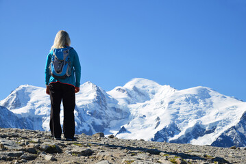 Hiker looking at the Mont Blanc from the summit of Le Brevent. French Alps, Chamonix, France.