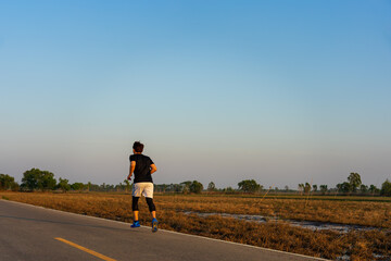 Fototapeta premium Young fitness asian man is running and jogging an outdoor workout on the road in the morning for lifestyle health.