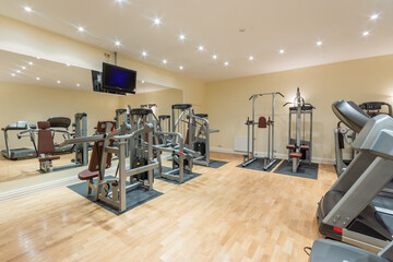 Fototapeta na wymiar A modern gym in a private house with a variety of numerous sports equipment.