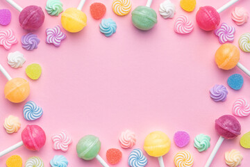 Sweet lollipops and candies on pink background