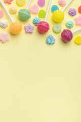 Sweet lollipops and candies on yellow background