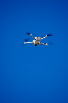a DJI Mavic Mini 3 drone in flight, blue sky in the background. RPA concept