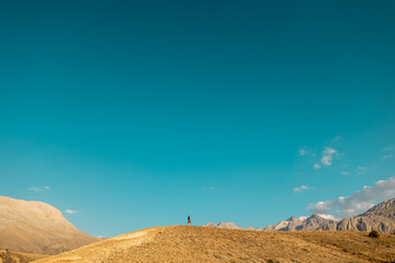 Hiking in the mountains. The girl is walking along a mountain path.