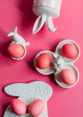 Easter composition with painted pink eggs and decorative figures with rabbits
