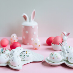 Easter composition with painted pink eggs and decorative figures with rabbits